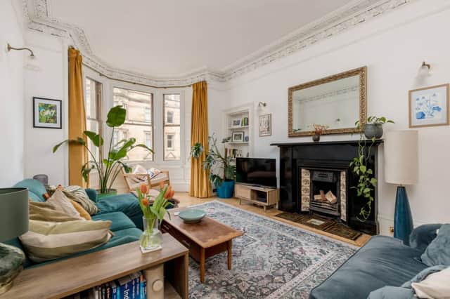 The flat has a beautiful living room with large bay windows and a fireplace.