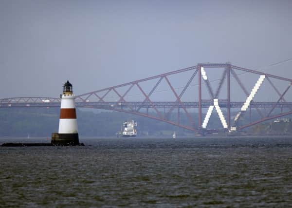 View of the Forth Bridge and lighthouse in the Firth of Forth.